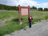 Ji-young is standing next to the sign for the continental divide.